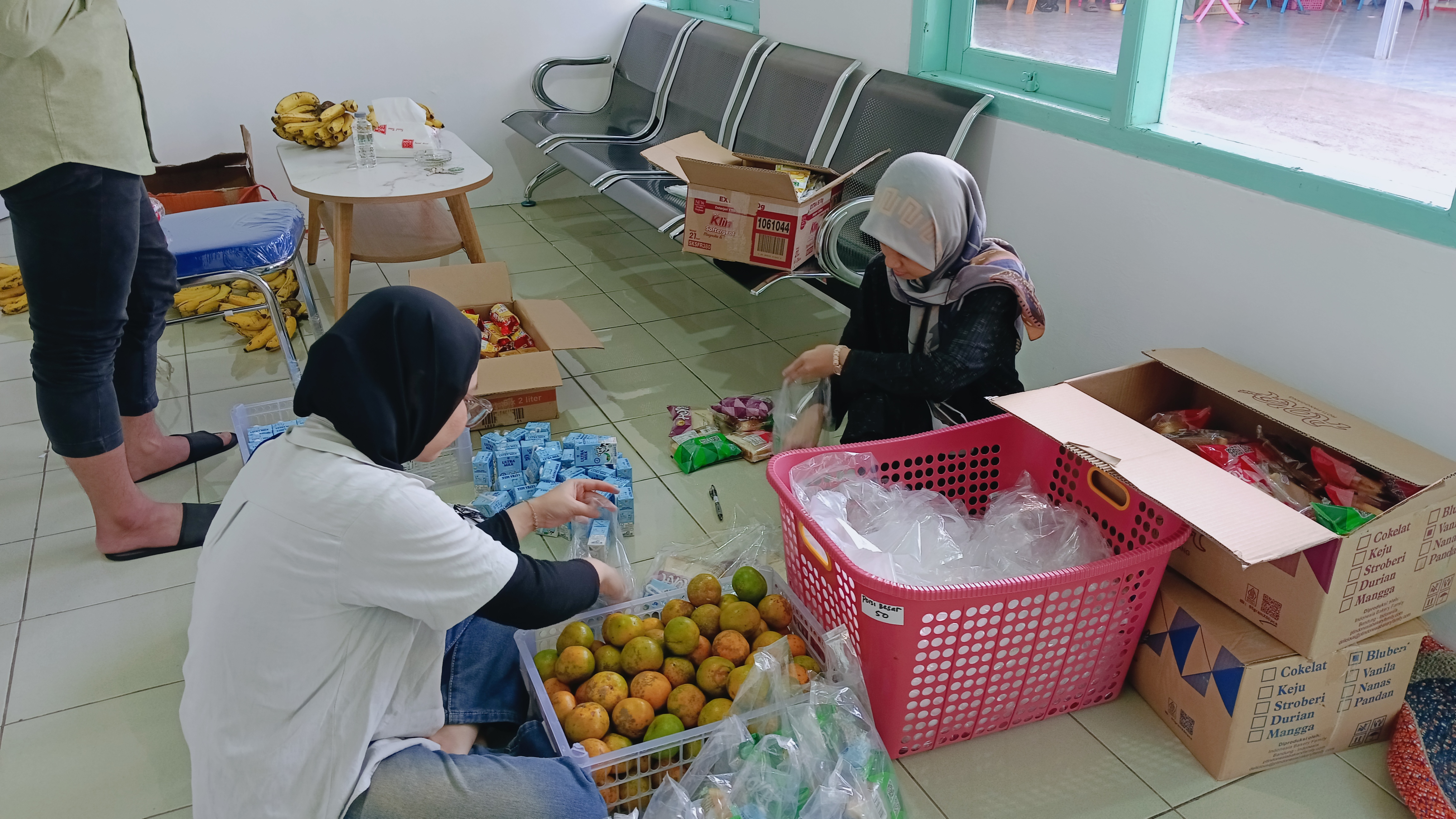 makanan bergizi, lengkap dengan buah jeruk segar, susu kotak, dan aneka kudapan.